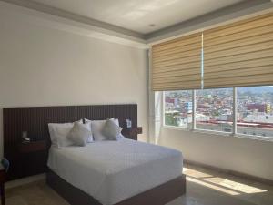 a bedroom with a bed and a large window at Hotel Zócalo Chilpancingo in Chilpancingo de los Bravos