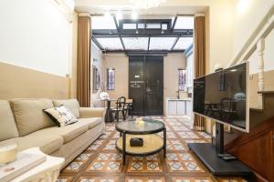 a living room with a couch and a tv at Shanghai Hills & Serendipity Family Boutique Near Line13 Mid Huaihai Road in Shanghai