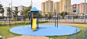 un parque infantil con equipo de juego azul y amarillo en Acogedor Apartamento en zona residencial con vista a la ciudad Wi-Fi 350 Mbps, en Bogotá