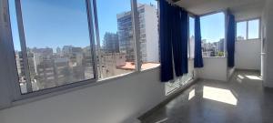 a room with windows with a view of a city at Gavilán Apartment in Buenos Aires