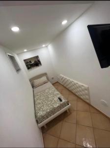 Habitación pequeña con cama y TV de pantalla plana. en Casa Marisa Pozzuoli, en Pozzuoli