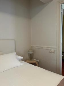 1 dormitorio con cama blanca y mesa en Apartamentos Ubaga en Ezcaray