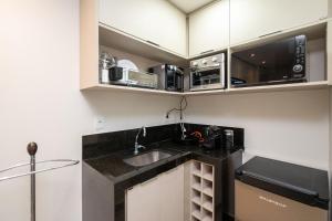 a kitchen with a sink and a microwave at Bristrol Evidence Hotel - BEH in Goiânia
