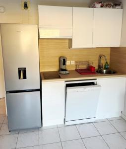 eine Küche mit einem weißen Kühlschrank und einem Geschirrspüler in der Unterkunft Joli 2 pièces cabine climatisé dans une résidence avec piscine in Cavalaire-sur-Mer