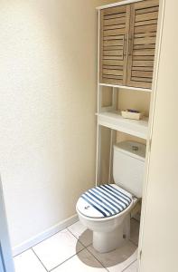 ein Badezimmer mit einem WC mit einem blauen und weißen Deckel in der Unterkunft Joli 2 pièces cabine climatisé dans une résidence avec piscine in Cavalaire-sur-Mer