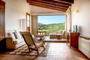 a living room with a couch and a chair and a window at Sos Ferres D'en Morey in Manacor