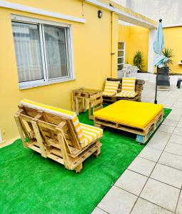 patio z krzesłami i stołami na zielonym piętrze w obiekcie DMCharme w mieście Ponta Delgada