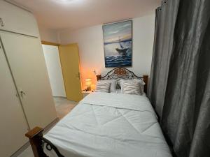 Schlafzimmer mit einem Bett mit weißer Bettwäsche und Kissen in der Unterkunft Villa ocean bord de mer louis in Libreville