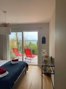 - une chambre avec un lit et un balcon avec des chaises dans l'établissement Brest and Breakfast vue mer, à Brest