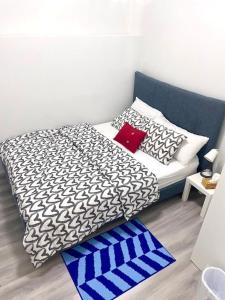 a bed with black and white sheets and a red pillow at Scarborough New 2-Bedroom Basement in Toronto