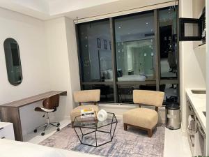 una stanza con due sedie e un tavolo e una finestra di NEW Luxury Hotel Suite Sandton City a Johannesburg