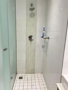 y baño con ducha y puerta de cristal. en NEW Luxury Hotel Suite Sandton City en Johannesburgo