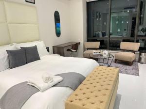 ヨハネスブルグにあるNEW Luxury Hotel Suite Sandton Cityのベッドルーム(白い大型ベッド、タオル付)