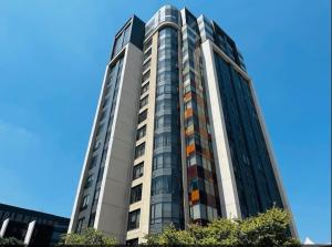 un edificio de cristal alto con un cielo azul en el fondo en NEW Luxury Hotel Suite Sandton City en Johannesburgo