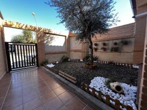 a courtyard with a tree and a fence at Un sueño en Toledo II, al lado de Puy du Fou in Argés