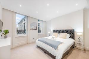 a white bedroom with a large bed and a window at Casa Italia near Kensington High Street - Wifi & Washing Machine in London