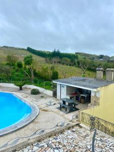 a house with a swimming pool next to a building at LouriVillage in Lourinhã