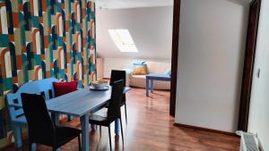 a dining room with a table and chairs and a couch at Apartament Pod Lipami in Suwałki