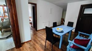 uma sala de jantar com uma mesa azul e cadeiras em Apartament Pod Lipami em Suwałki