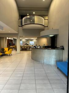 a lobby of a hospital with yellow chairs and a bar at Hawthorn Extended Stay by Wyndham Port Arthur in Port Arthur