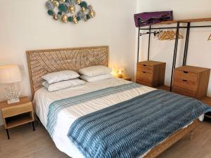 1 dormitorio con 1 cama con manta de rayas azul y blanco en L Etoile de Mer - Piscine chauffee, en Saint-Vincent-sur-Jard
