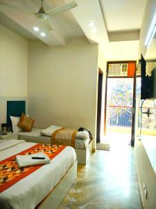 a bedroom with two beds and a large window at Hotel Diamond Stay, Nizamuddin Railway Station in New Delhi