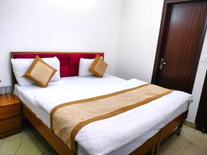 a bedroom with a large bed with a red headboard at Hotel Diamond Stay, Nizamuddin Railway Station in New Delhi