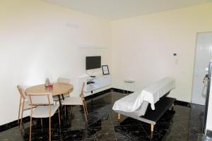 Zimmer mit einem Tisch und einem Bett sowie einem Tisch und Stühlen in der Unterkunft Cidadela Apartamento in Praia