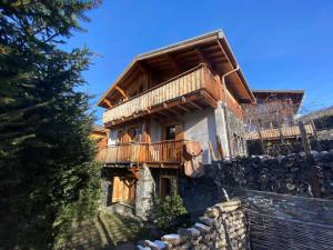 a log home with a balcony on a stone wall at Chalet de charme 8 pers avec parking, cheminée et terrasse - Saint-Martin-de-Belleville - FR-1-452-35 in Saint-Martin-de-Belleville