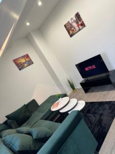 uma sala de estar com um sofá e uma televisão de ecrã plano em PARIS by D&J Apartment‘s Altenessen Nord em Essen