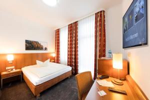 um quarto de hotel com uma cama e uma secretária em Hotel Reichshof garni em Schwerte