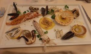 un piatto di cibo con frutti di mare su un tavolo di Hotel Ristorante Ca' Nova a Venezia