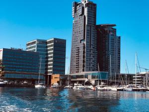 miasto z wysokimi budynkami i łodziami w wodzie w obiekcie I Love Gdynia Apartments - apartament z parkingiem w mieście Gdynia