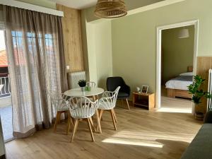 Edessa Woodland Retreat في إيديسا: غرفة معيشة مع طاولة وكراسي وسرير