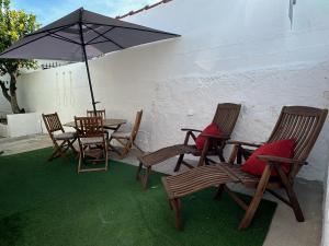 eine Gruppe Stühle und einen Tisch mit einem Sonnenschirm in der Unterkunft Refúgio Alentejano in Estremoz