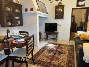 ein Wohnzimmer mit einem Tisch und einem TV in der Unterkunft Refúgio Alentejano in Estremoz