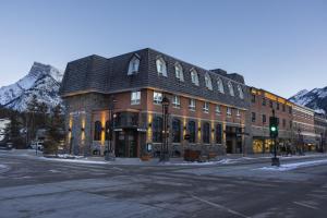 a large building on a street with mountains in the background at Mount Royal Hotel in Banff