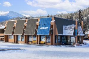 a building with a sign on the side of it in the snow at Marmot Lodge Jasper in Jasper