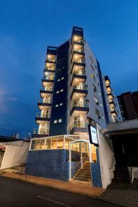 a tall building with a staircase in front of it at Lym Flat Hotel in Uberlândia