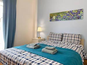 una camera da letto con un letto blu e asciugamani di Glorious Mediterranean 顶层海景公寓 ad Atene