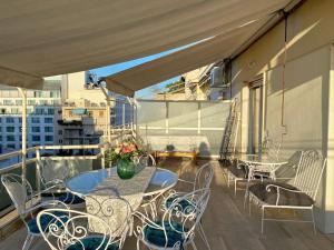 un patio con tavoli e sedie su un balcone di Glorious Mediterranean 顶层海景公寓 ad Atene