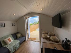 a small living room with a couch and a tv at Cow Hill Pod in Fort William