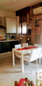 a kitchen with a table and white chairs in a room at Alice nel paese delle meraviglie 