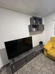 a living room with a flat screen tv on a wall at Lovely rooms near the metro in Paterna