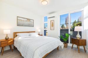 a white bedroom with a large bed and a window at 2BR 2BA Capitol Hill Cozy Haven- Rooftop in Seattle