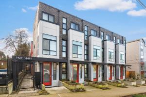 a brick building with red doors on a street at 2BR 2BA Capitol Hill Cozy Haven- Rooftop in Seattle