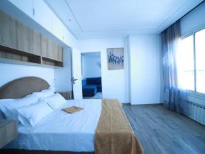 a bedroom with a large bed and a large window at La reine de Sidi Bou Said in Sidi Bou Saïd