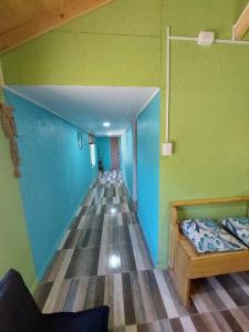 una camera con un corridoio con un letto e pareti verdi di Cabaña El Aromo a Linares