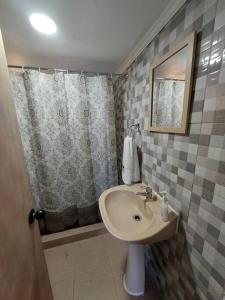 un baño con lavabo y ducha en Cabaña El Aromo, en Linares