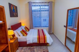 1 dormitorio con cama y ventana grande en F.A.M Homes, en Dar es Salaam